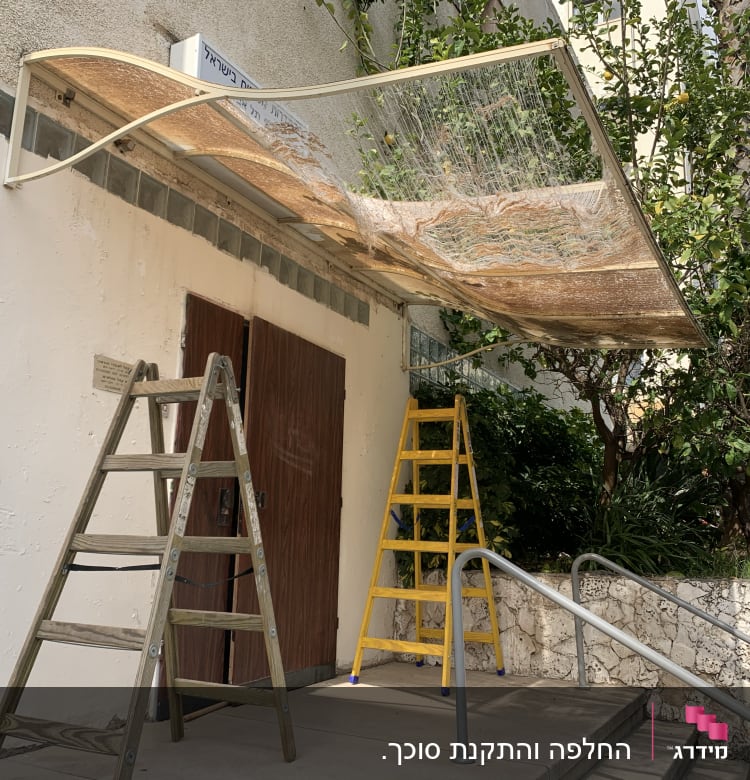 שני סולמות ליד סוכך שקוף מותקן על קיר